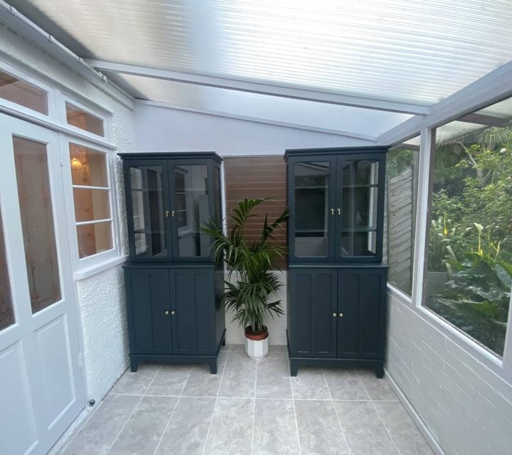 Decorated conservatory with contrasting painted display cabinets