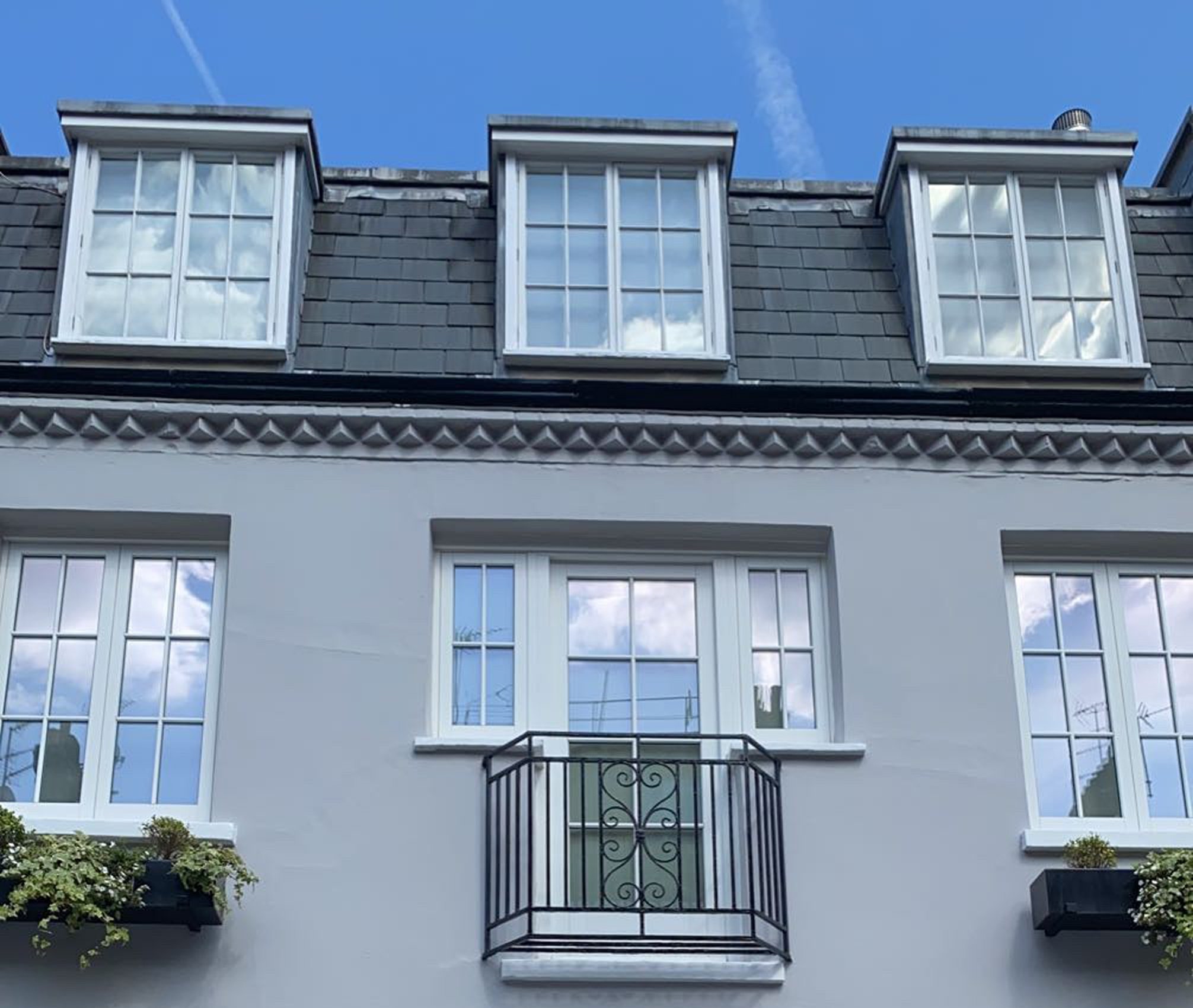 Grey painted house exterior with white window frames