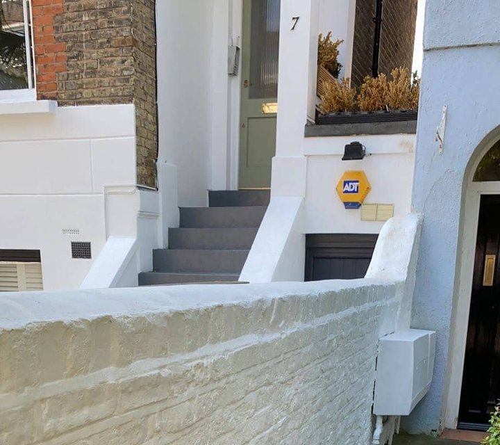 Freshly painted white exterior brick garden wall