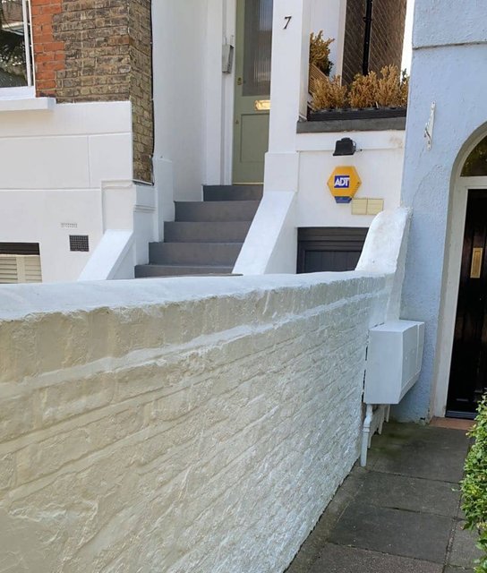 Freshly painted white exterior brick garden wall