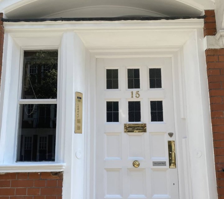 White front door and decorative surround after exterior painting