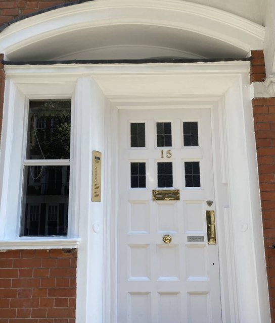 White front door and decorative surround after exterior painting