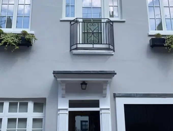 Grey-painted residential house exterior with white trim