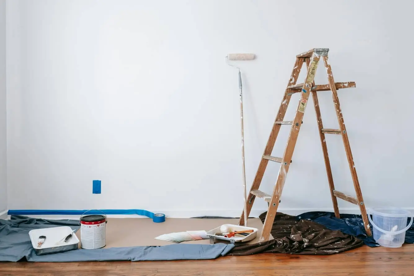 ladder and paint roller against wall